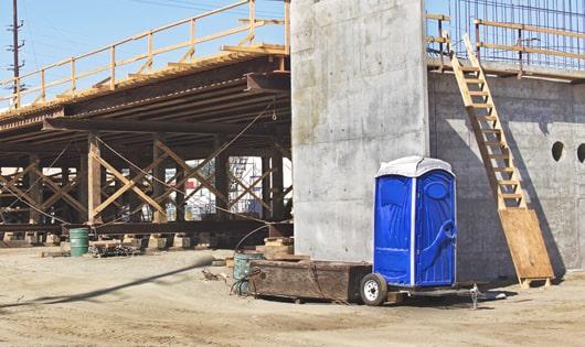 portable restrooms set up for workers’ use at a busy job site